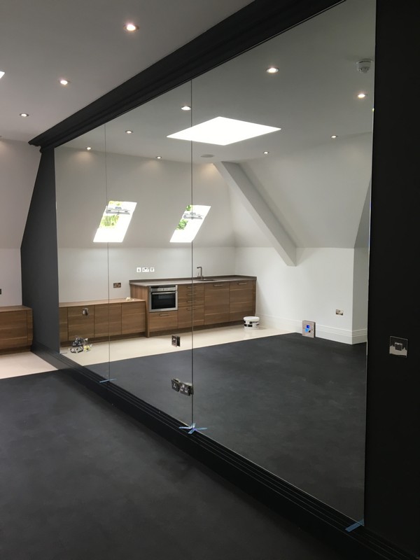 Frameless glass partition in loft conversion by Hampton glaziers