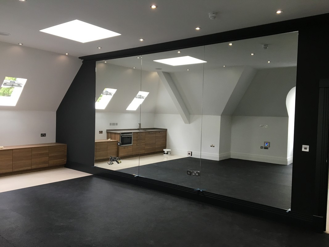 Frameless glass wall dividing loft conversion in Hampton
